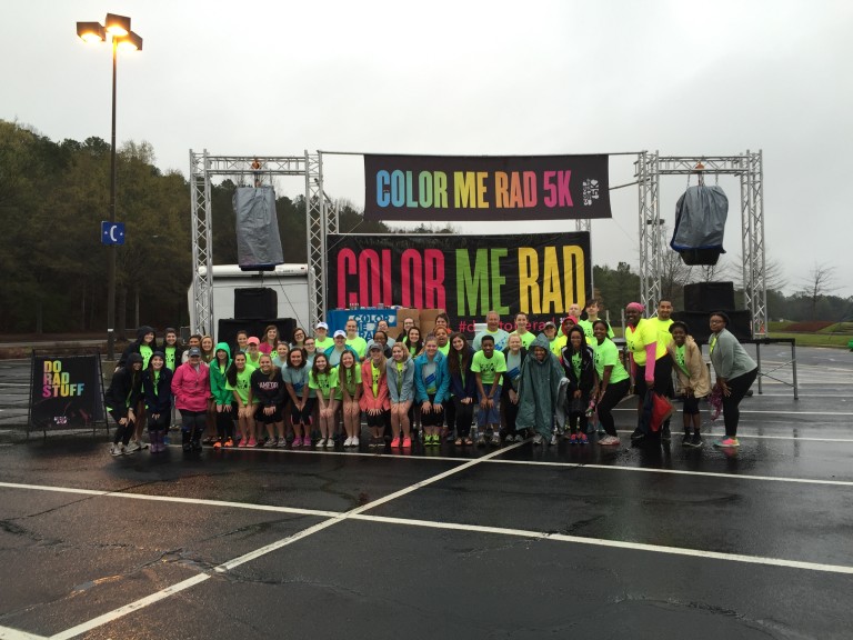 Color Me Rad volunteers pose in front of the stage