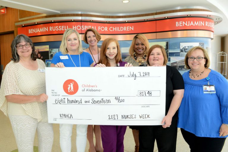 RMHCA and Children's of Alabama staff hold up a ceremonial check for the funds raised