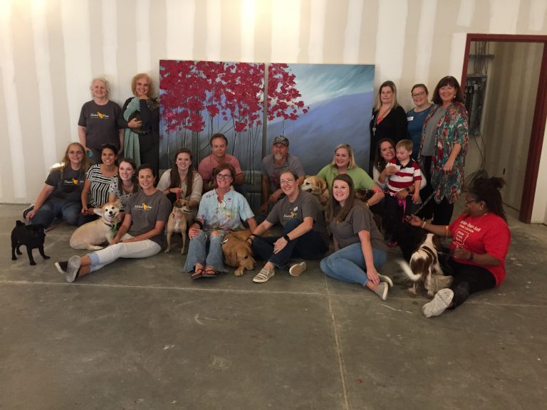 RMHCA and Hand in Paw staff gather around the finished artwork.