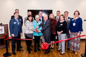 CEO Katherine Estes Billmeier, Co-Founder Marianne Sharbel and Board President Randy Nichols cut the ribbon on the $8.2 million expansion. They are surrounded by Board Members.