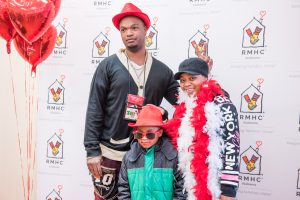 An RMHCA family gets silly at the photo booth with hats, glasses and feather boas!