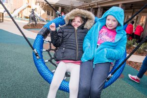 Raylee and Maddy Kate enjoy swinging on the playground.