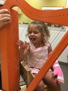 Cate plays the harp as part of her constraint therapy. Source: Capps family