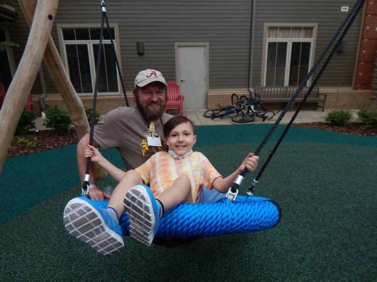 Miley and David enjoy time on the playground swinging