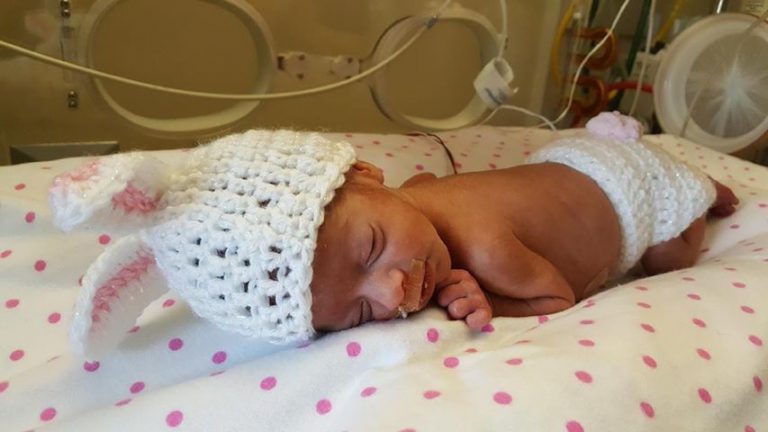 Baby Emmalyn Carter sleeps with a knitted bunny ear hat on.