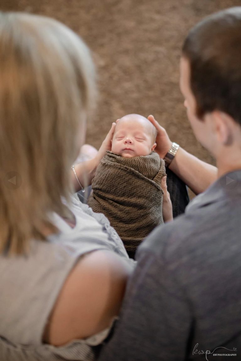 Pickens Family photo of mom and dad holding baby boy.