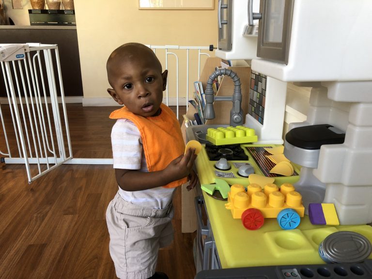 Christian Duncan plays in the play kitchen.