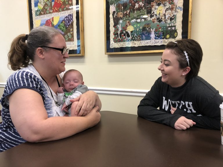 Trish King holds her son Dale while talking to Caitlyn Rigsbee.
