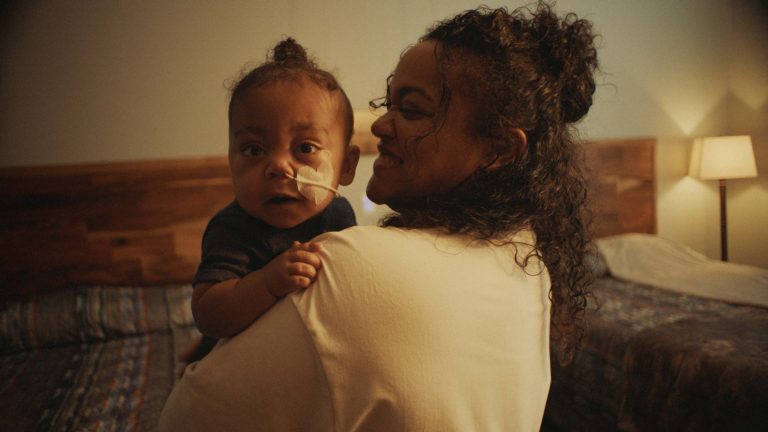A mother holds her toddler son