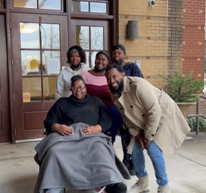 Pastor Mike Jr poses for a picture with four members of the Miller family