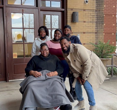 Pastor Mike Jr poses for a picture with four members of the Miller family