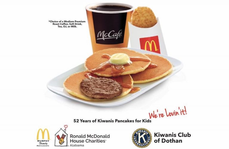 A plate of pancakes with sausage, hash browns and a cup of coffee