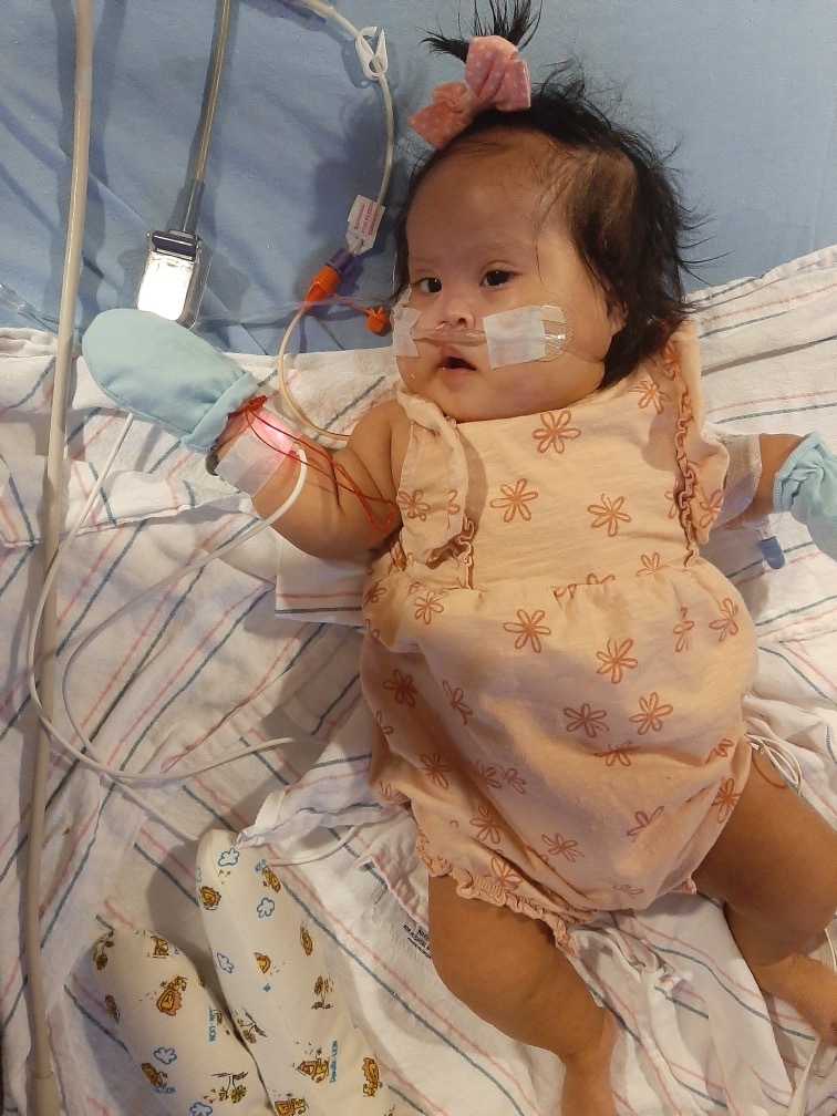 A baby girl relaxes in her crib
