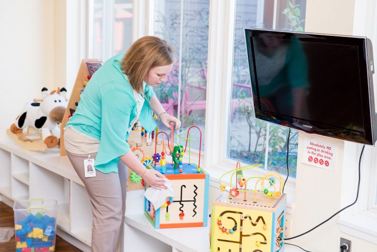 A volunteer cleans the play area