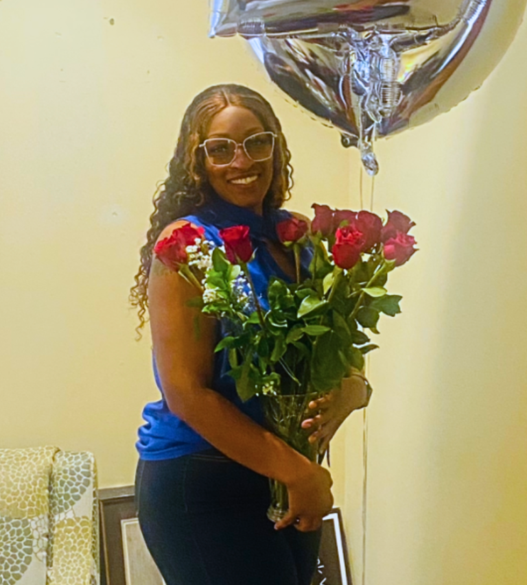 Ms. April holds a bouquet of flowers