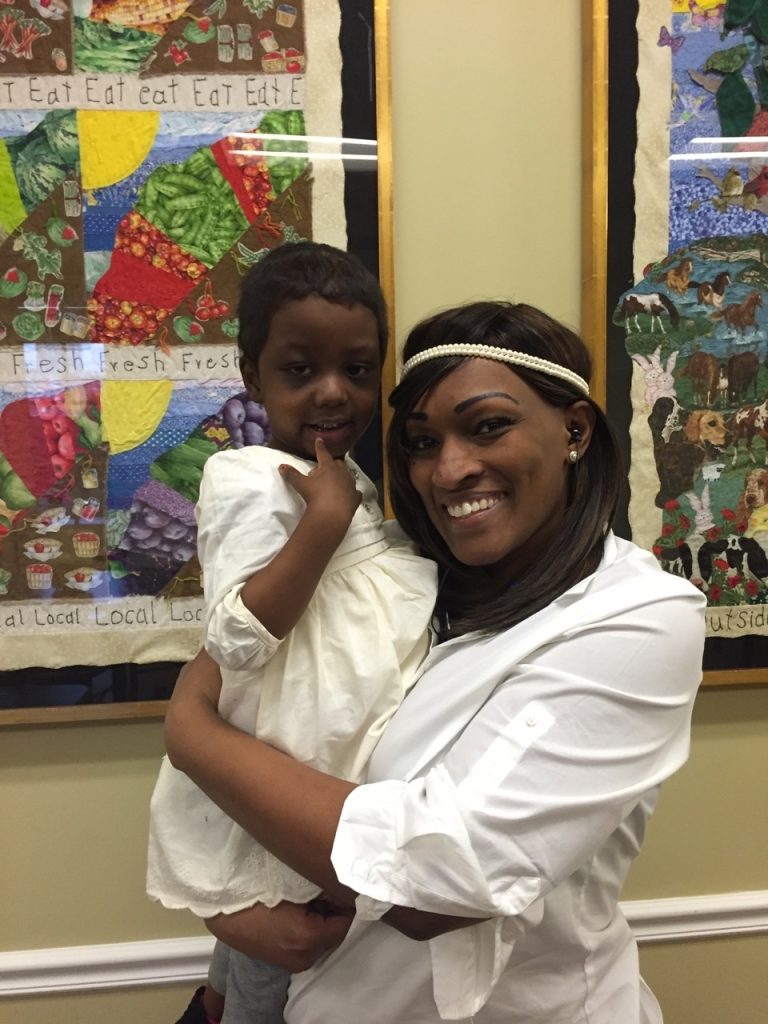 Ms. April hugs a child