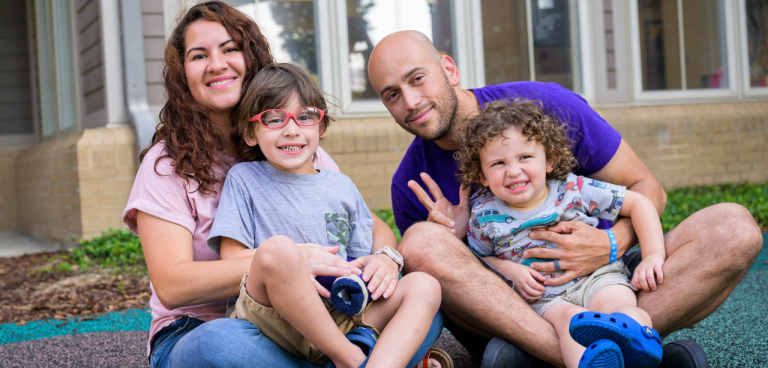 A woman, dad and two boys pose for a photo