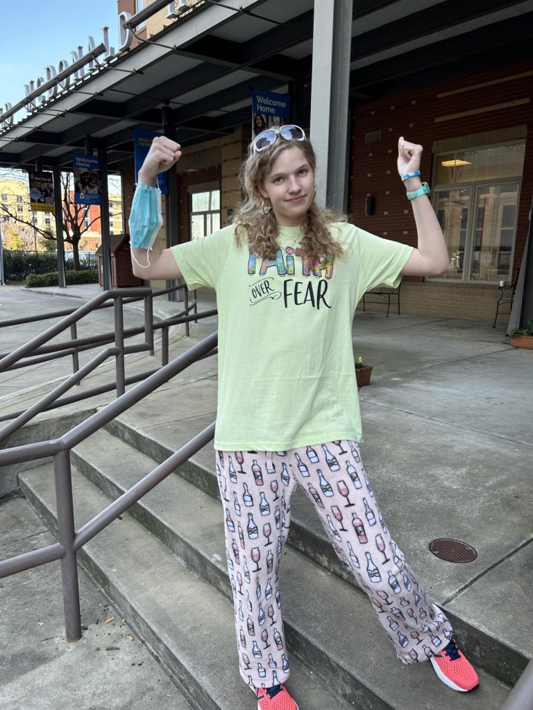 A teenager stands in front of the Ronald McDonald House