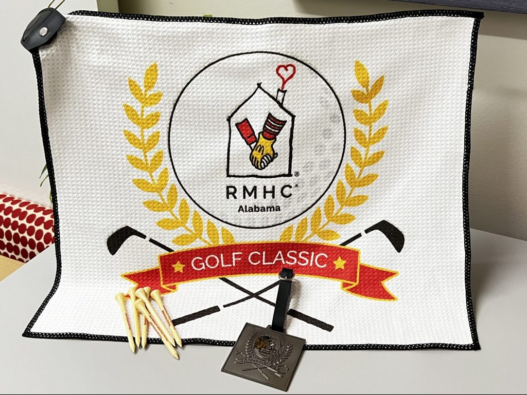 A golf towel, group of golf tees and a bag tag.