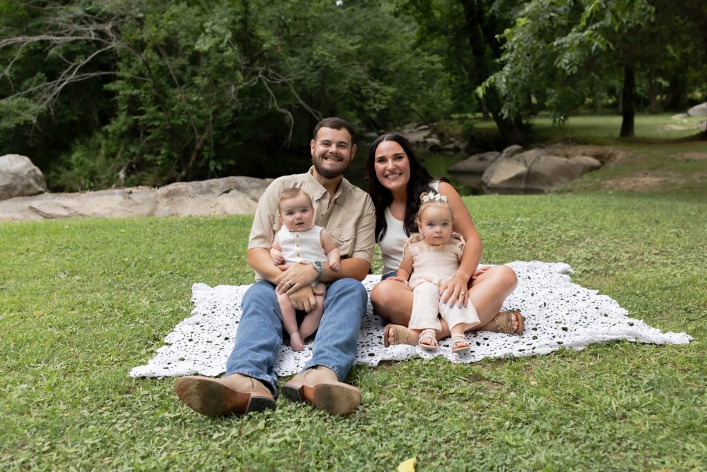 A father and mother hold their children for a photo.