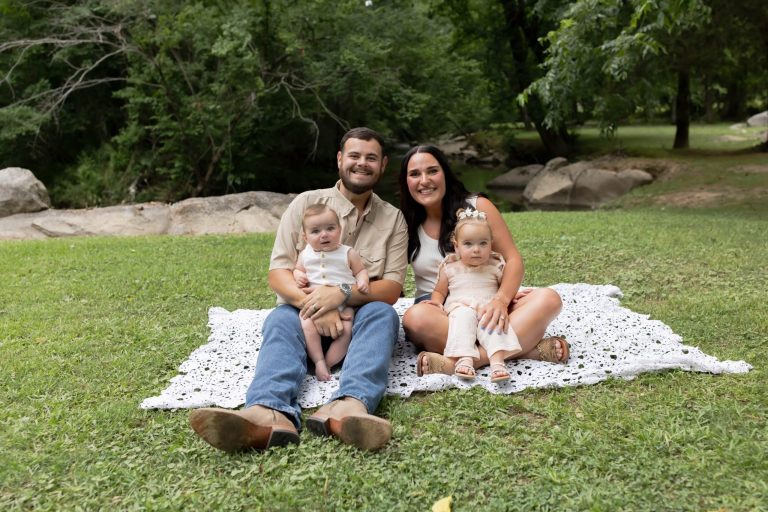 A father and mother hold their children for a photo.