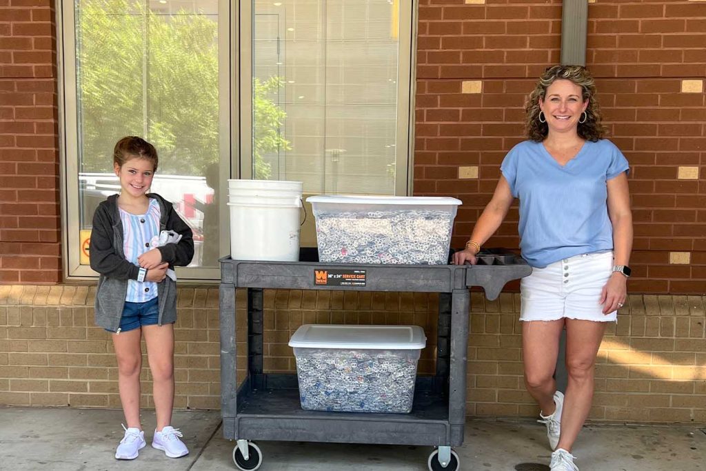 A woman and daughter donates pop tabs