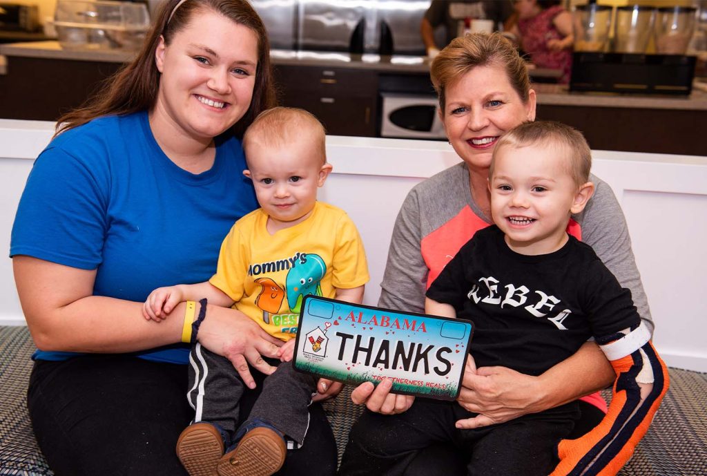Thanks with family of 4 holding car tag