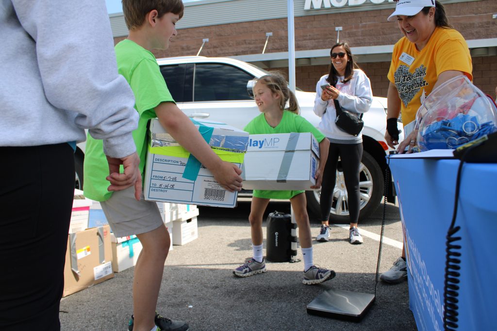 Kids weighing Pop Tabs at Pop Tab Party