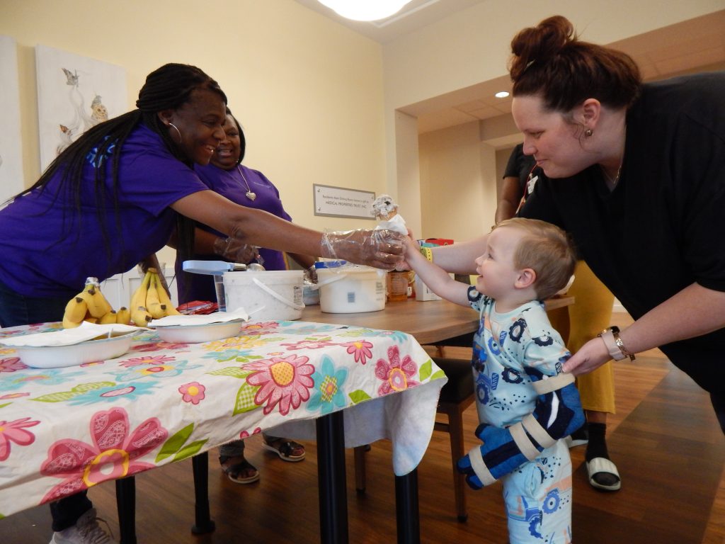 A volunteer serves ice cream to a guest family