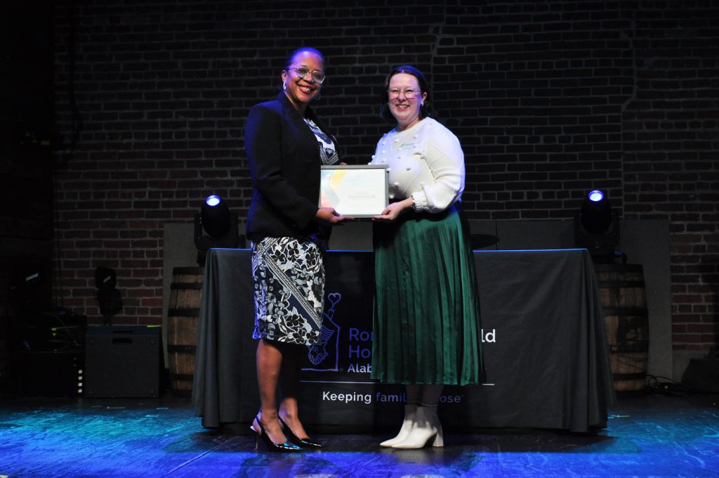 A woman presents and award to a second woman