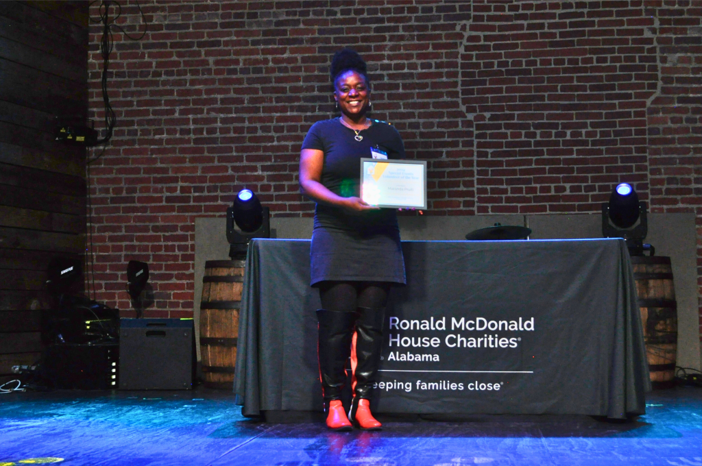 A woman holds an award