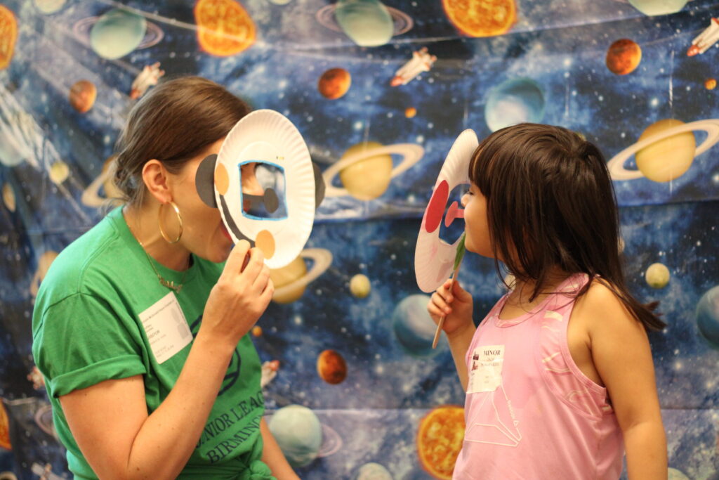 Volunteer doing space craft with child.